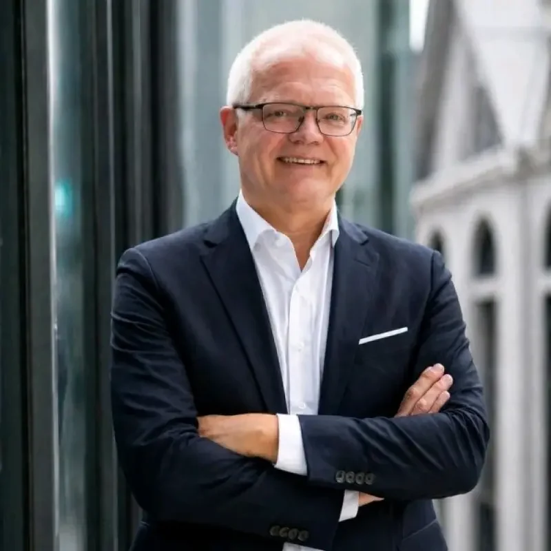 Professionelles Businessportrait eines Geschäftsmanns im Anzug in moderner Unternehmensumgebung