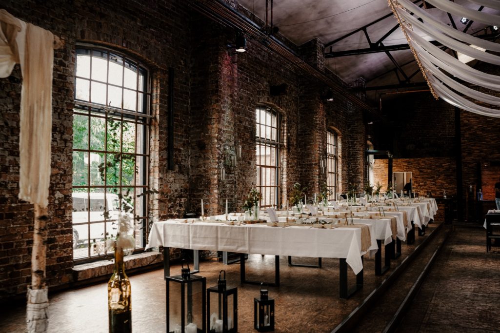 Eleganter, festlich gedeckter Tisch in einem mit Backsteinen verkleideten Restaurant.