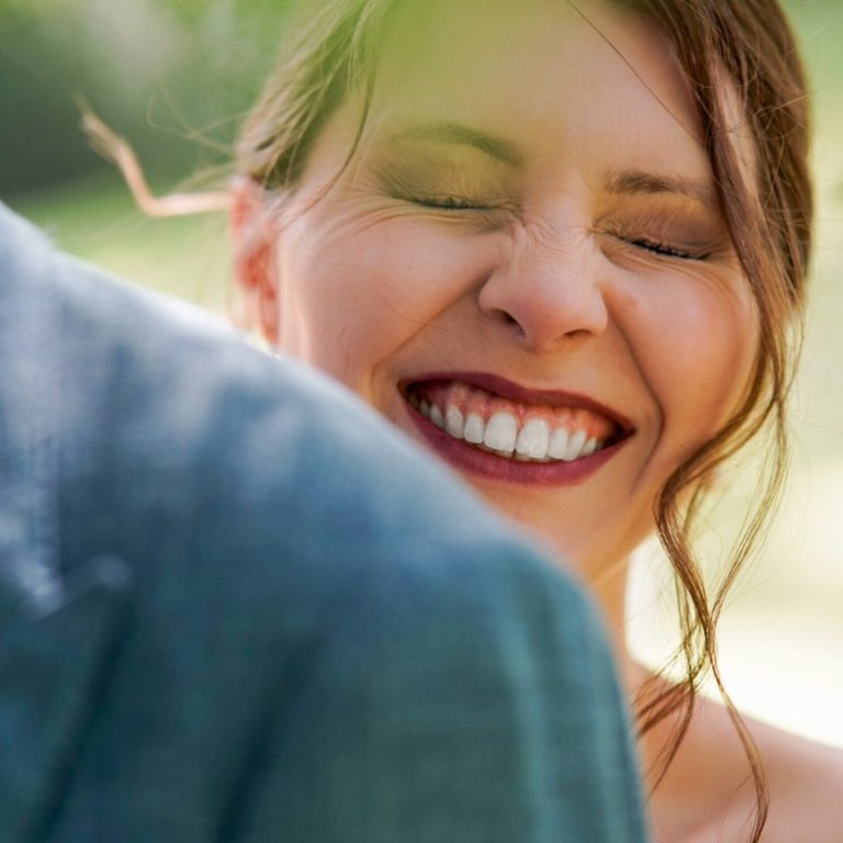 Braut und Bräutigam küssen sich in einem romantischen Moment im Freien.