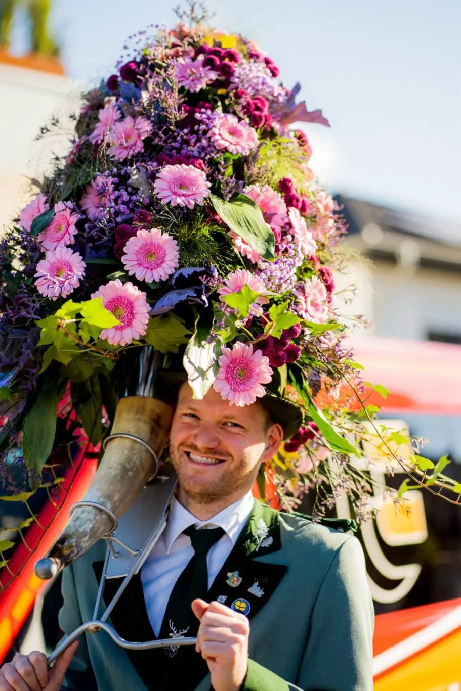Schützenkönig mit großem Blumenschmuck bei traditionellem Fest
